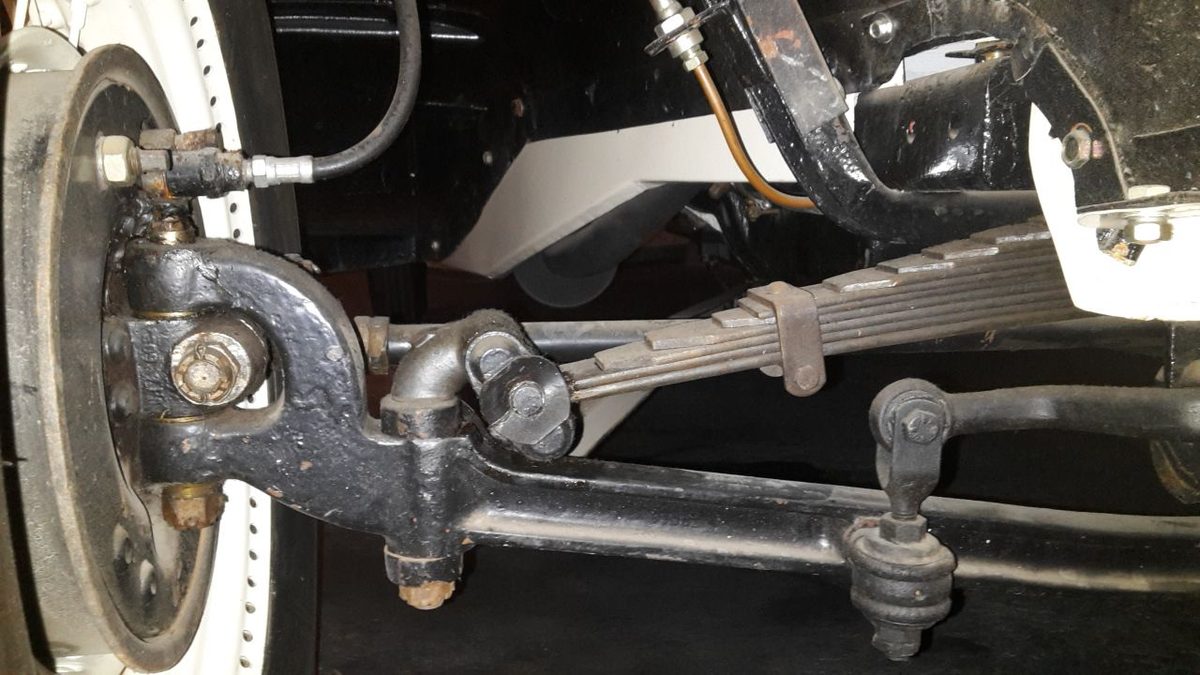 The front axle of a vintage car: a solid beam axle with the kingpin and steering knuckle at the
wheel end, connected by a track rod